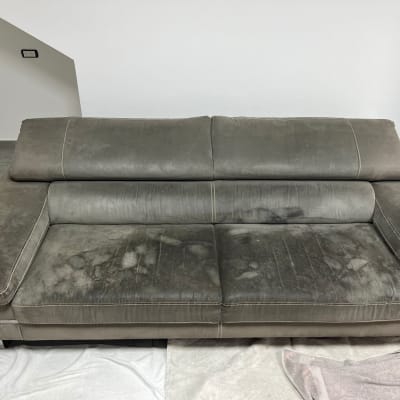 ספה מלוכלכת עם כתמים כהים על הריפוד