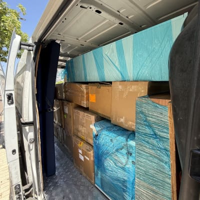 משאית עם קרטונים וציוד עטוף בניילון כחול