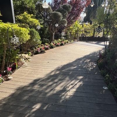 שביל עץ עם פרחים צבעוניים וגדרות מתכת