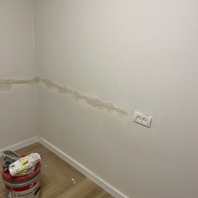 קיר עם תיקון טיח ודלי צבע על הרצפה