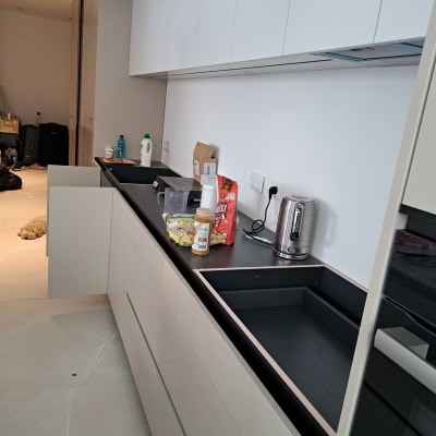 מטבח עם משטח עבודה, קומקום, בקבוקים ומוצרי מזון