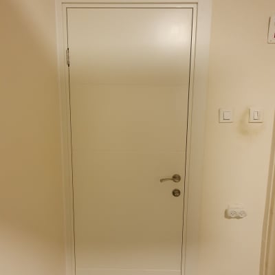 דלת לבנה עם ידית מתכת ומתגים ליד