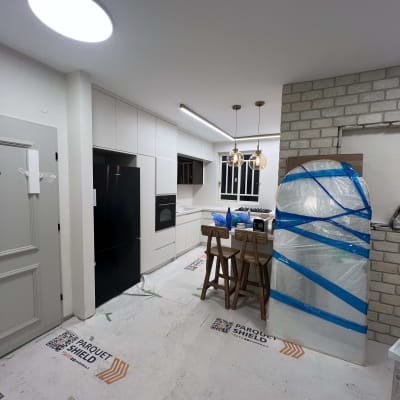 מטבח חדש עם ריצוף מגן, כיסאות ודלפק.