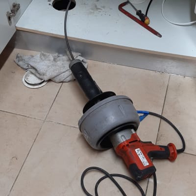 כלי עבודה של אינסטלטור מתחת לכיור עם צינור