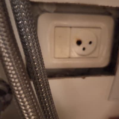 שקע חשמלי עם סימני שריפה ליד צינורות מתכת