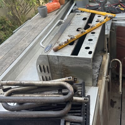 חלקי גריל מתכתיים וכלי עבודה על שולחן עבודה