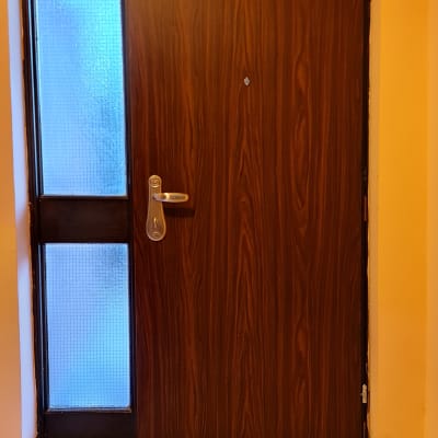 דלת עץ עם ידית מתכת וחלון זכוכית בצד