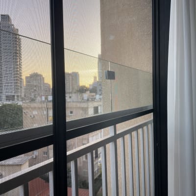 חלון זכוכית עם מסגרת מתכת ונוף עירוני