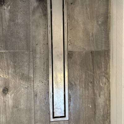 תעלת ניקוז מתכתית ברצפת עץ