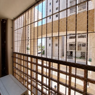 רשת יונים מותקנת על מרפסת בבניין מגורים