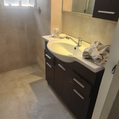 כיור אמבטיה עם ברז ומגבת על השיש