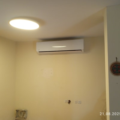 מזגן מותקן על קיר בחדר עם תאורה עגולה