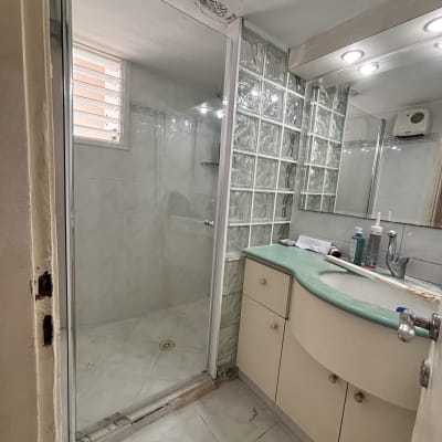 חדר אמבטיה עם מקלחת, כיור ומראה