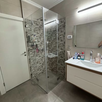 מקלחון זכוכית עם אריחים מעוצבים בחדר אמבטיה