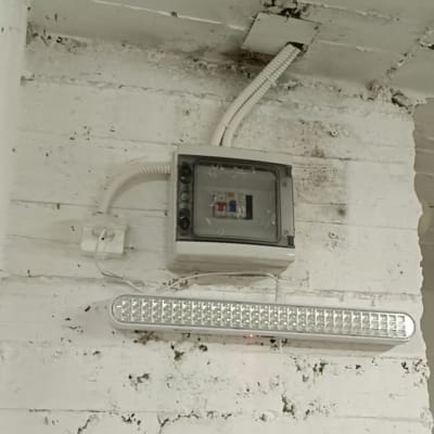 תיבת חשמל ומנורת לד על קיר לבן