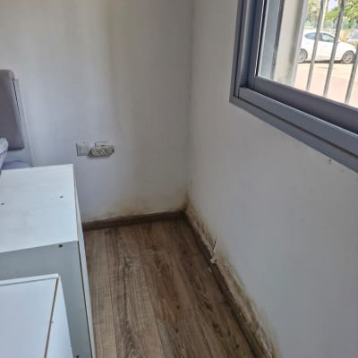 קיר עם סימני רטיבות ורצפת עץ