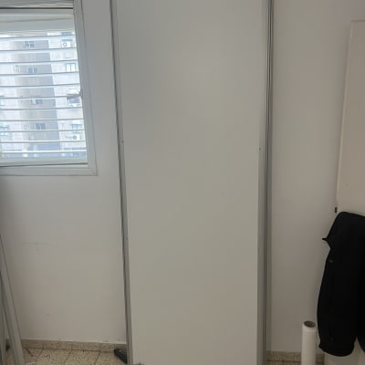 דלת לבנה עומדת ליד חלון בחדר