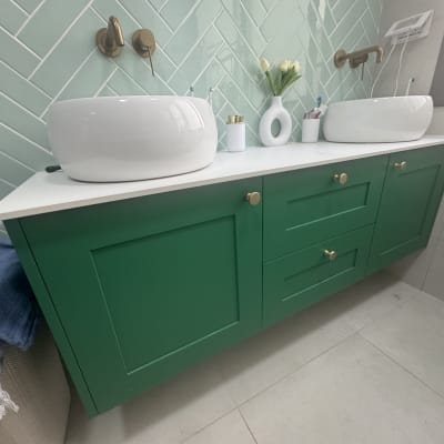 ארון אמבטיה ירוק עם כיורים לבנים וברזים מוזהבים