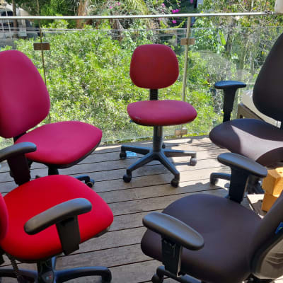 כיסאות משרדיים על מרפסת עץ עם צמחייה ברקע