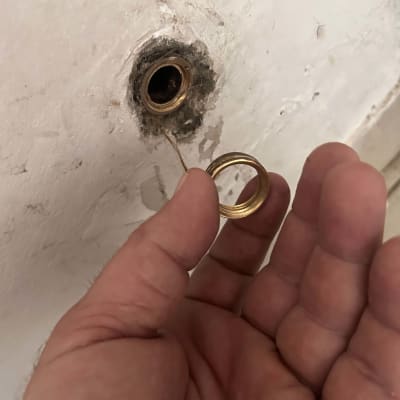 יד מחזיקה טבעת ליד צינור בקיר