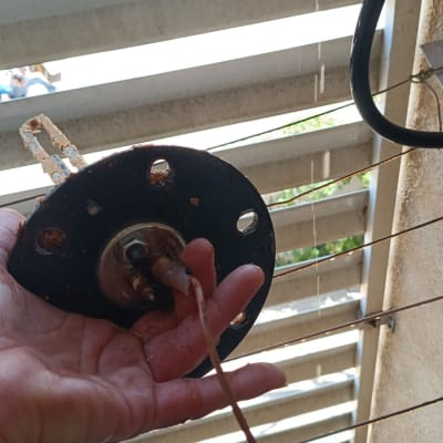 חלק מתכת מוחזק ביד ליד תריסים