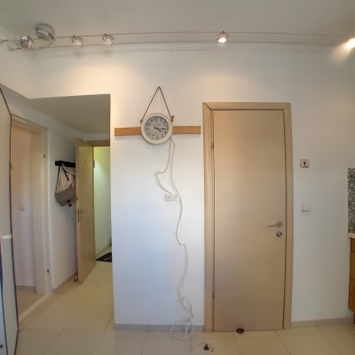 קיר לבן עם שעון תלוי וחוט חשמל