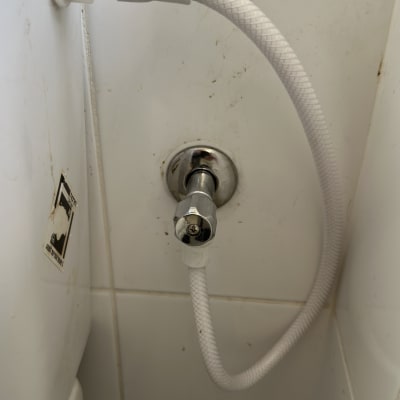 צינור מים מחובר לשסתום מתכת בקיר