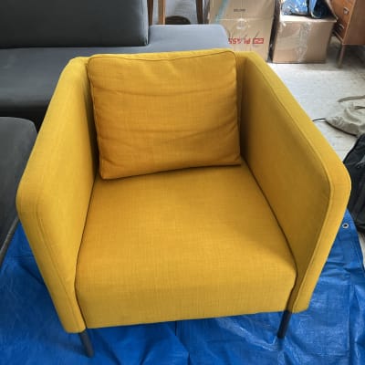 כיסא צהוב על יריעת פלסטיק כחולה עם שואב אבק