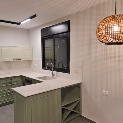 מטבח משופץ עם ארונות ירוקים וכיור חדש