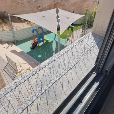 דוקרנים להרחקת יונים על אדן חלון ליד גן ילדים