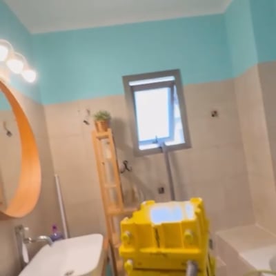 חדר אמבטיה צבוע בגוונים כחולים עם ציוד ניקוי צהוב