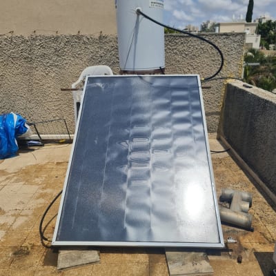 דוד שמש עם קולטים על גג מרוצף