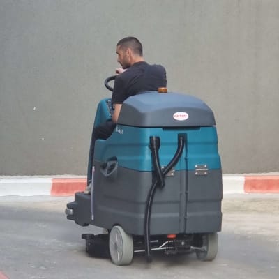 אדם נוהג במכונת שטיפה על כביש