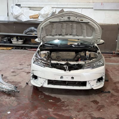 רכב עם מכסה מנוע פתוח במוסך לתיקון