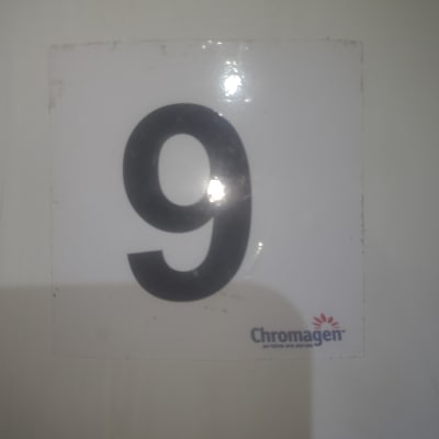 מדבקה עם מספר 9 ולוגו של כרומגן על רקע לבן