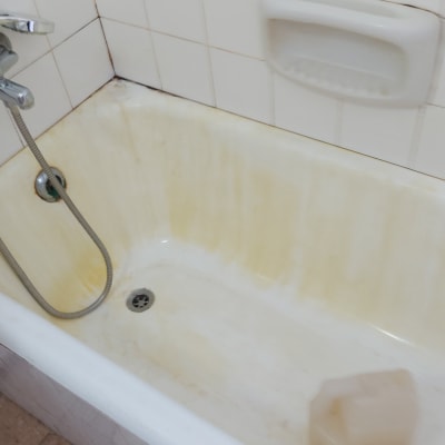 אמבטיה מלוכלכת עם כתמים, בקבוק חומר ניקוי