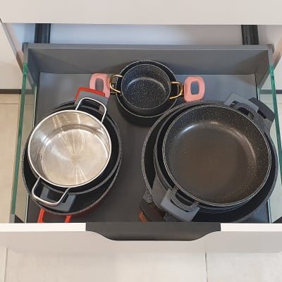 סירים ומחבתות מאורגנים במגירה במטבח