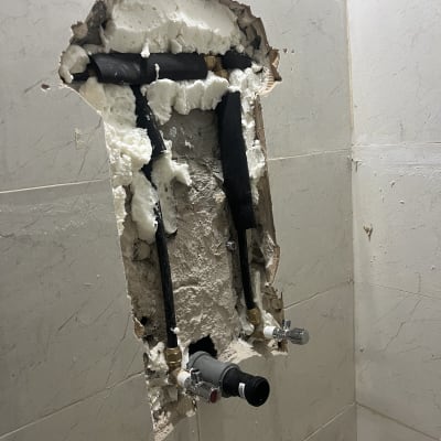 צנרת חשופה בקיר עם קצף בידוד