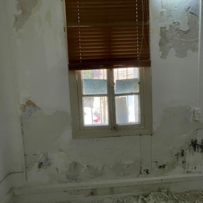 קיר מתקלף עם צבע מתקלף ותריסים חומים