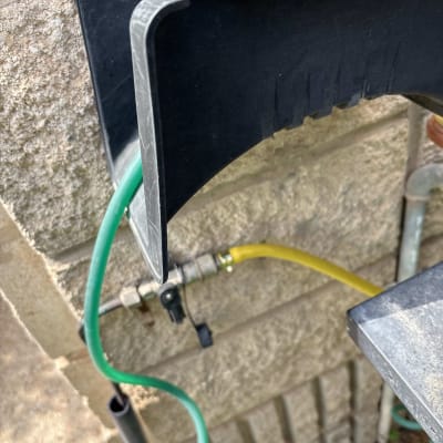 צינור ירוק וצהוב מחובר לקיר עם מתקן פלסטיק