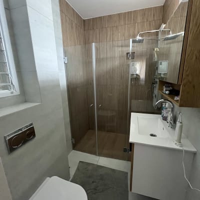 חדר אמבטיה משופץ עם מקלחון זכוכית וכיור מודרני