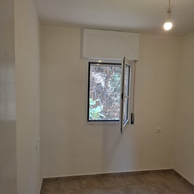 חדר ריק עם קירות צבועים וחלון פתוח