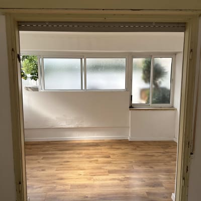 רצפת פרקט עץ בחדר מואר עם חלונות גדולים