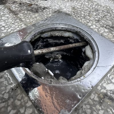 פתח ביוב עם כלי עבודה לניקוי