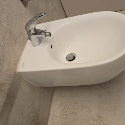 כיור לבן עם ברז כרום על קיר אריחים