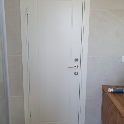 דלת לבנה עם ידית וכפתור מתכת