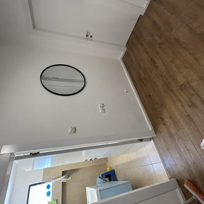 קיר צבוע לבן עם מראה עגולה