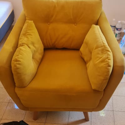 כורסה צהובה עם צינור ניקוי על הרצפה