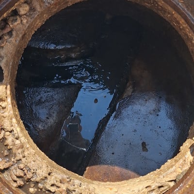 פתח ביוב עם מים עומדים ולכלוך מסביב