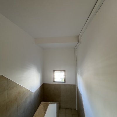 קירות צבועים בלבן במדרגות עם חלון קטן